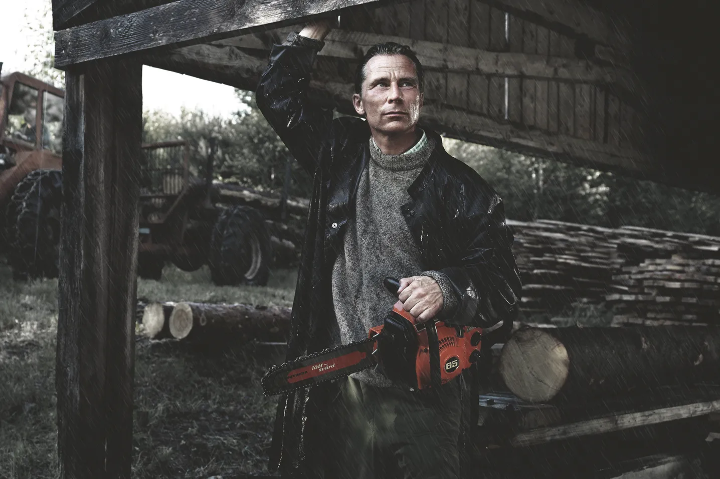 Man Under Outdoor Roof Holding Husqvarna Chainsaw